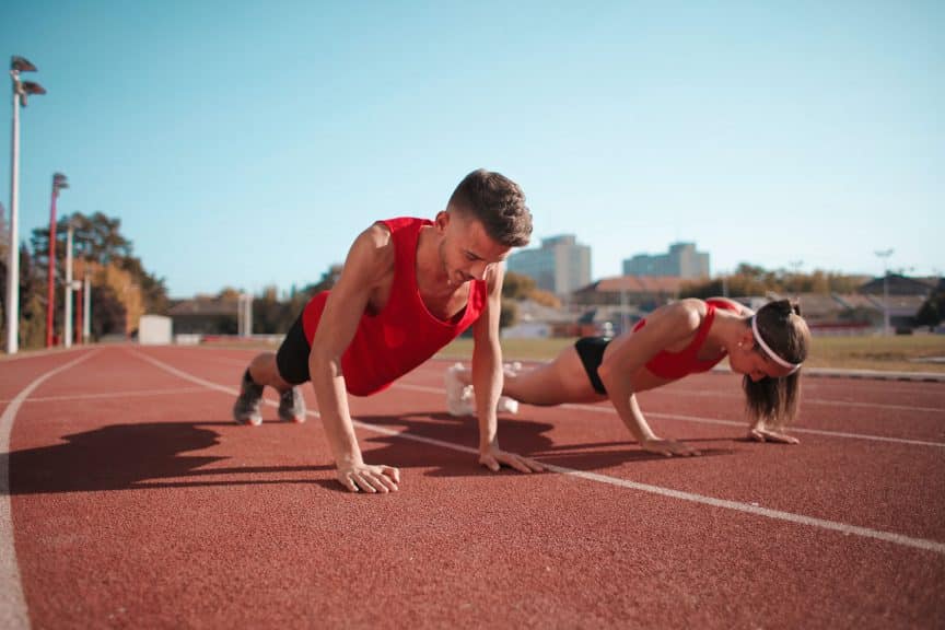 Mann und Frau trainieren auf Leichtathletikbahn